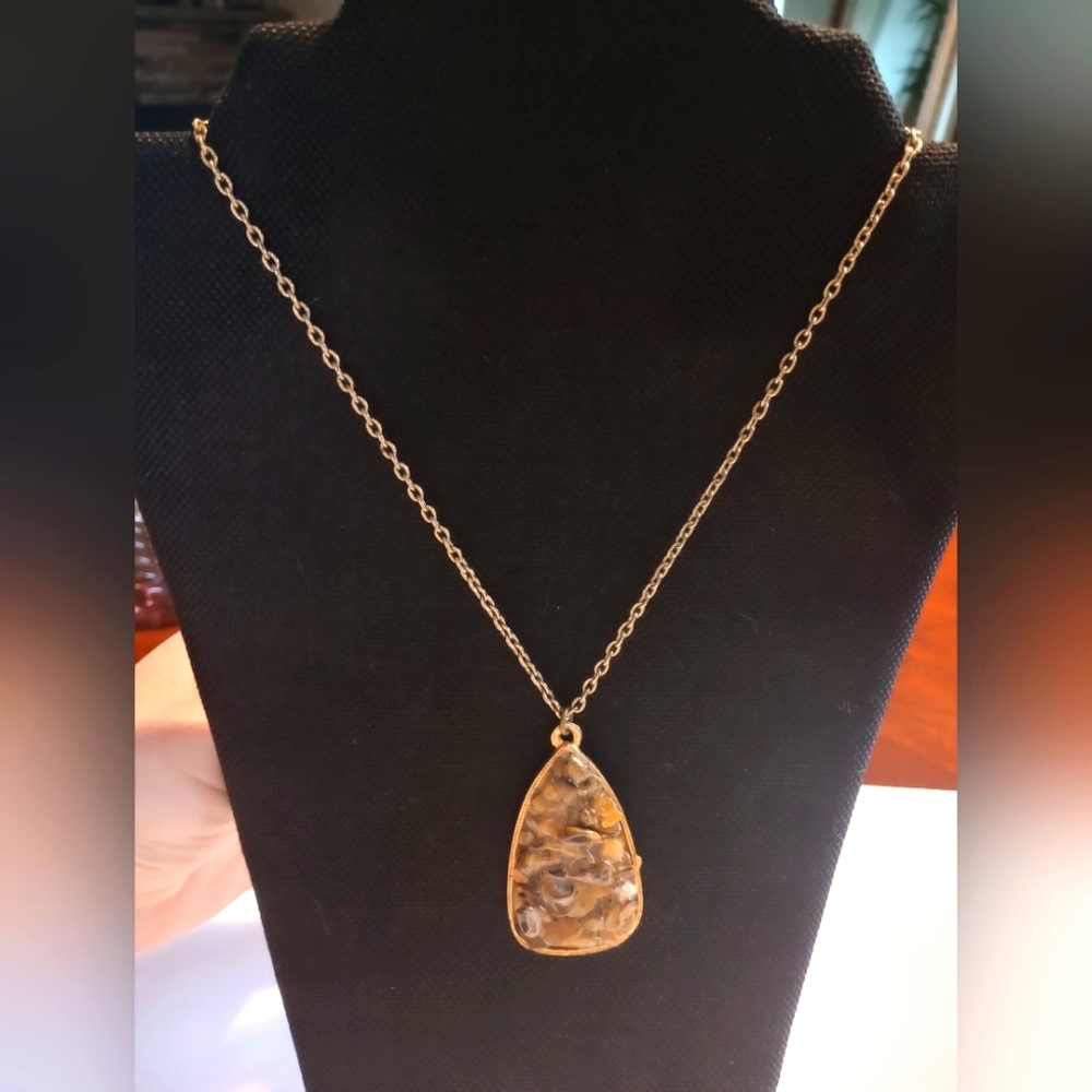 Teardrop pendant necklace features a mosaic inlay of polished brown and amber